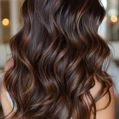 A perfect example of a coffee brown balayage that I specialize in for Indian skin tones. Notice how the hand-painted highlights create a seamless, sun-kissed dimension, while the soft waves show off the rich, glossy color.