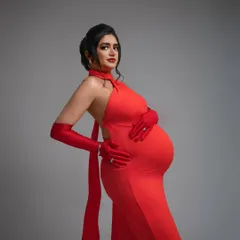 A portrait of pure confidence. The backless detail and form-fitting silhouette of this red gown are designed to celebrate your changing body with style and grace. This is maternity fashion at its boldest.