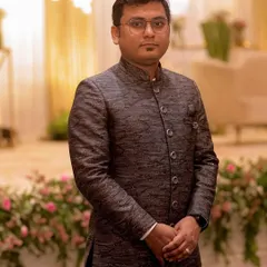 Mr. Gaurav Khandelwal in a custom-made indo-western achkan. The textured grey fabric and clean silhouette offer a sophisticated and modern take on traditional groomswear.