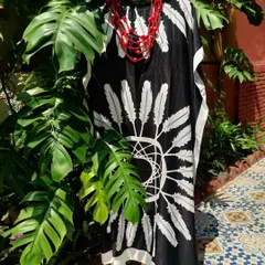 This black and white feather-print kaftan is a standout piece from the Autumn collection. Paired with a bold red necklace, it creates a dramatic and stylish look that is also incredibly comfortable.