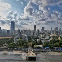 A clear aerial shot of the Mata Ramabai Ambedkar Smruti Viewing Deck at Dadar Chowpatty, showing its connection to the shore and the surrounding urban environment.