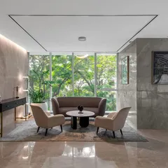 A quiet seating area in the Asian Paints office, with large windows overlooking a lush green landscape. The use of muted tones, natural materials, and comfortable furniture creates a serene space for relaxation and focused conversation.