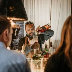 A bartender is just a pharmacist with a limited inventory. Here, one of my expert mixologists carefully prepares a classic whiskey drink for a guest at an elegant evening event.