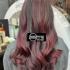 A beautiful example of a cherry red hair color. The soft waves and rich tones create a trendy and fashionable look that's full of life.