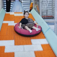 Here we go. A young guest enjoys a ride down our popular doughnut slide. This unique slide provides a fun and gentle thrill for kids of various ages.