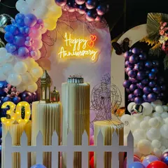 A close-up of the 30th anniversary decor, showing the details of the neon sign, cake pedestals, and lighted marquee numbers. The white picket fence adds a charming touch to the overall design.