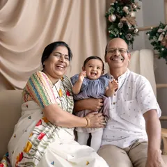 The whole family laughing together. The grandparents' joyful expressions as they interact with their granddaughter make this a truly heartwarming and precious memory.
