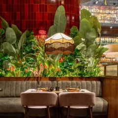 Here, my vertically stacked, glossy red tiles create a stunning feature wall that serves as a backdrop for the seating area at Hikki. The vibrant color and clean lines add a sense of energy and modernity, contrasting beautifully with the lush greenery.
