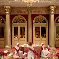 The regal and historic ballroom at the Taj Mahal Palace, Mumbai, set for an intimate and luxurious reception. Its rich red and gold interiors provide a backdrop of unparalleled elegance.