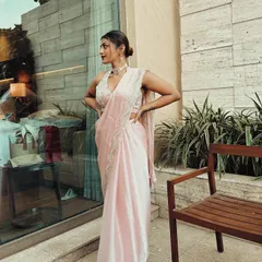 A full-length view of this beautiful pink saree. The way it drapes creates a graceful silhouette, perfect for a wedding reception or a festive gathering. The modern blouse adds a contemporary touch.