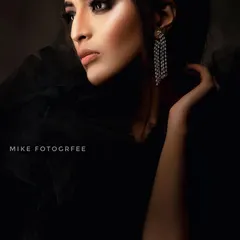 A profile view that uses shadow to create a dramatic, high-fashion feel. This technique, known as low-key lighting, is great for emphasizing the model's features and the shine of the diamond earrings.