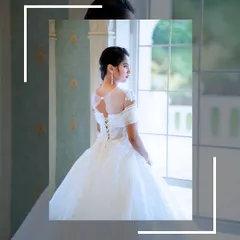 A view of the back of the white gown, showing the elegant corset lacing and sheer sleeves.