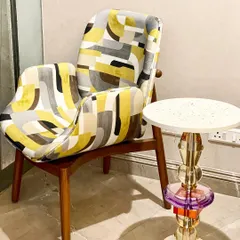 Our "Soft Serve" armchair, with its bold geometric pattern and solid teak wood frame, is a perfect statement piece. Here, we've paired it with the "Floss" accent table to create a quirky and modern corner.