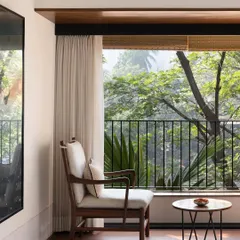 We create intimate moments within a home, like this quiet seating area for two. By perfectly framing the lush greenery outside, we turn a simple window into a private retreat, blending the interior with nature.