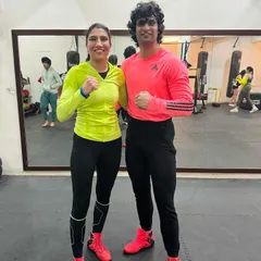 Strength and skill on display. A female boxer and her training partner pose after a demanding workout, showcasing the athletic results of dedicated boxing training.