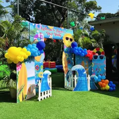 Welcome to the pool party! This entrance arch is decorated with surfboards, waves, and a sun wearing sunglasses, setting a fun, beachy vibe.