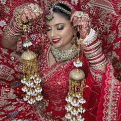 A candid moment of the bride with her kalire. The rich red of her lehenga and lipstick creates a vibrant and celebratory look.