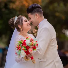 A romantic portrait of a Catholic couple, their smiles illuminated by the golden hour light, capturing the happiness of their wedding day.