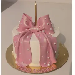 A chic cake for Saanvi's 18th birthday. This butterscotch caramel cake is decorated with a large, shimmering pink fondant bow and delicate pearl details.