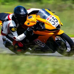 A motion-blurred shot capturing the pure speed and focus of a rider on a straight. While cornering is key, I also teach throttle control and acceleration techniques for maximum performance.