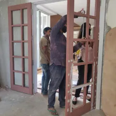 Installing custom elements like these traditional double doors requires careful craftsmanship. This image captures my team at work, fitting the doors that will lead into the media room. It's these details, executed with care, that give a home its unique character and solid feel.