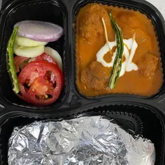 My Malai Kofta tiffin features soft vegetable koftas in a luscious, creamy gravy. It's served here with foil-wrapped rotis to keep them warm and a side of fresh salad.