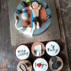The full gym-themed set, including the main cake with a fondant figurine and matching cupcakes with toppers like weights, towels, and motivational messages.