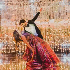Lost in their own bubble of love and light. The couple shares a dance under a mesmerizing installation of thousands of hanging bulbs, creating a magical, starry-night effect for their reception.