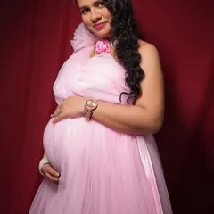 A close-up portrait showing the delicate details on the shoulder of the pink gown. I focus on capturing that pregnancy glow and making you feel confident and beautiful.