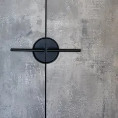 A close-up of the unique circular handle against the concrete-textured laminate. It’s small details like this that give a simple wardrobe a strong personality and a high-end feel.