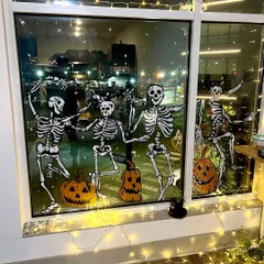 The dancing skeletons look even spookier at night with the city lights in the background. A fun way to decorate for Halloween.