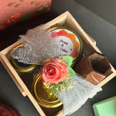 A closer look at a curated Diwali hamper in a sustainable wooden crate, decorated with a flower. It's a beautiful and eco-friendly way to gift.