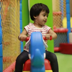 A toddler enjoys a ride in our dedicated soft play area. We ensure even the smallest children have a safe and stimulating space to call their own.