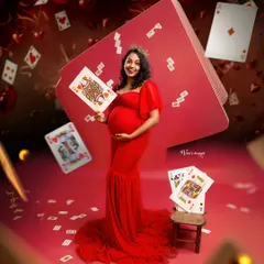 The Queen of Hearts. This highly creative and fun concept uses playing cards and a vibrant red theme to create a whimsical and unforgettable maternity portrait.