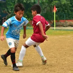 A fierce 1v1 battle for possession during a tournament match. Our players are trained to be aggressive, fair, and relentless in every challenge.