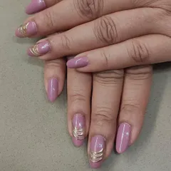A unique way to add a metallic touch. These mauve-pink nails are accented with a 3D gold wire wrap design, creating a look that is both elegant and modern.