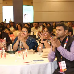 A table of delegates at a conference, clapping with enthusiasm. It is always a joy to see the audience connect with the stories.