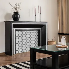 A custom-designed faux fireplace serves as a charming focal point, featuring patterned tiles that echo the staircase design. This element adds a touch of classic European character to the living space.