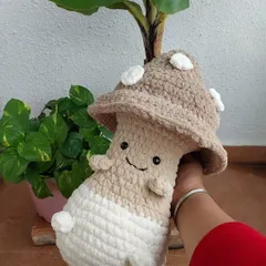 A close-up of my cute mushroom plushie, showing its sweet, smiling face and soft, huggable texture.