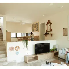 The split-level design of the Franklin Residence creates a visual connection between the living room and the dining area above. The space is filled with natural light and the family's personal art collection.