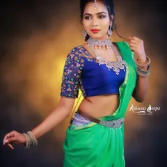 A vibrant green saree paired with a contrasting royal blue embroidered blouse. This look is perfect for guests who want to make a statement at a wedding.
