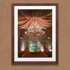 An example of our luxury event decor, featuring a stunning floral arrangement under an opulent crystal chandelier. We illuminate your celebrations with unmatched sophistication.