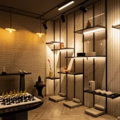This space is a showcase of neutral materials working in harmony. A vertically grooved wall with integrated shelving is set against a textured brick wall, with low seating and a marble chessboard creating an inviting and sophisticated lounge area.
