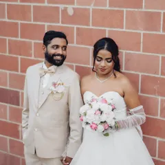A candid, shared glance between the couple against a simple brick backdrop. My goal is to capture these unposed, real interactions that tell your story.