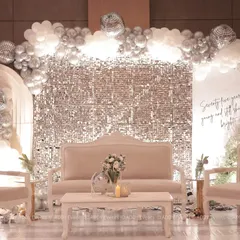 We designed this glamorous and modern stage for a 75th birthday celebration. The setup features a silver shimmer wall, a balloon arch in a monochrome palette, and elegant velvet seating, proving that milestone events can be both sophisticated and fun.