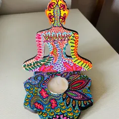 A vibrant, hand-painted Buddha candle holder, showcasing a rainbow of colors and detailed patterns. It's a piece of art that brings both light and joy.