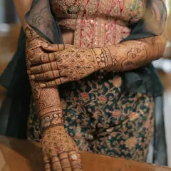 The bride's intricate mehendi is a work of art that complements her stunning bridal outfit.