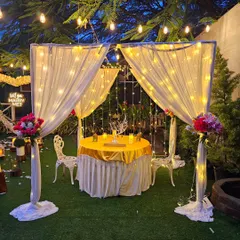 This is one of my classic intimate dinner cabanas, perfect for an anniversary or proposal. Draped in white fabric with fairy lights, it creates a private and romantic dining space for two in the garden.