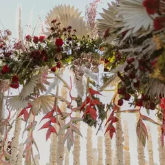 A closer look at the intricate floral work on our Sabyasachi-inspired 'Regal Rustic Reverie' mandap. We layered rich red florals with dried pampas grass and other rustic elements to create a design that is full of texture, depth, and romance.