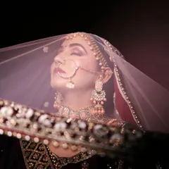 A classic bridal portrait with a modern, artistic touch. We use light and shadow to capture the bride's serene beauty and anticipation from behind her veil.